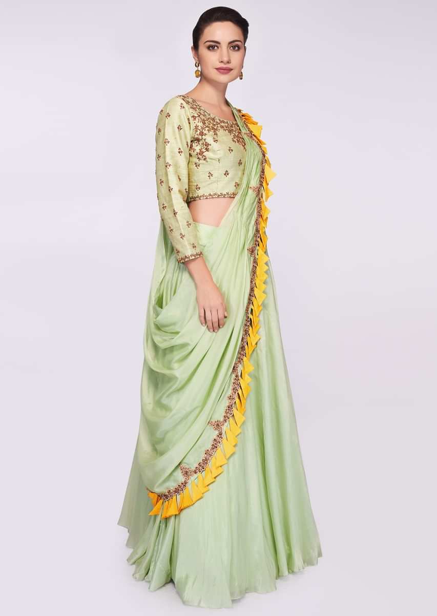 Pista green raw silk blouse in embroidery and butti paired with matching organza skirt and wrap around 