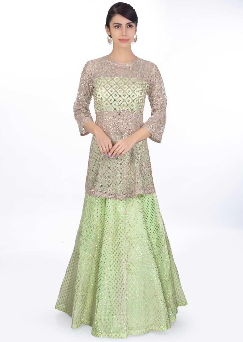 Pista green weaved lehenga paired with a strap crop top along with embroidered net top layer and net dupatta