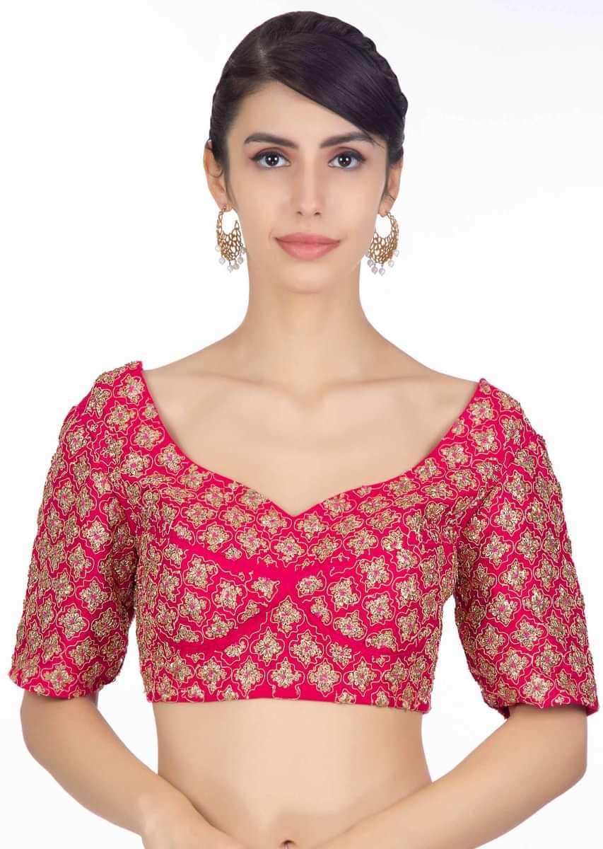 Rani pink raw silk heavily embellished lehenga paired with embroidered blouse and powder pink net dupatta