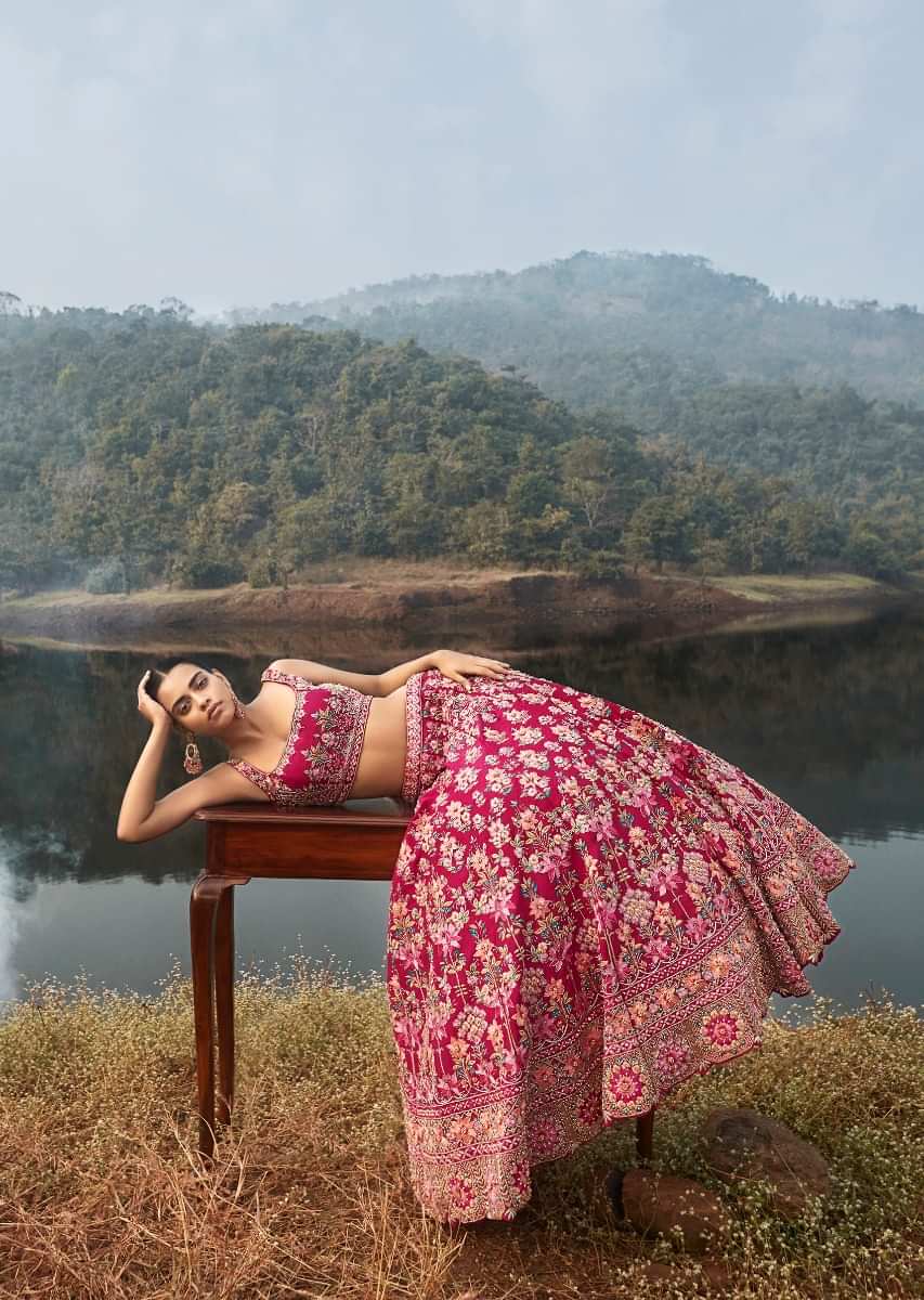 Rani Pink Lehenga Choli In Raw Silk With Colorful Resham And Cut Dana Embroidered Summertime Flowers And Elaborate Border 
