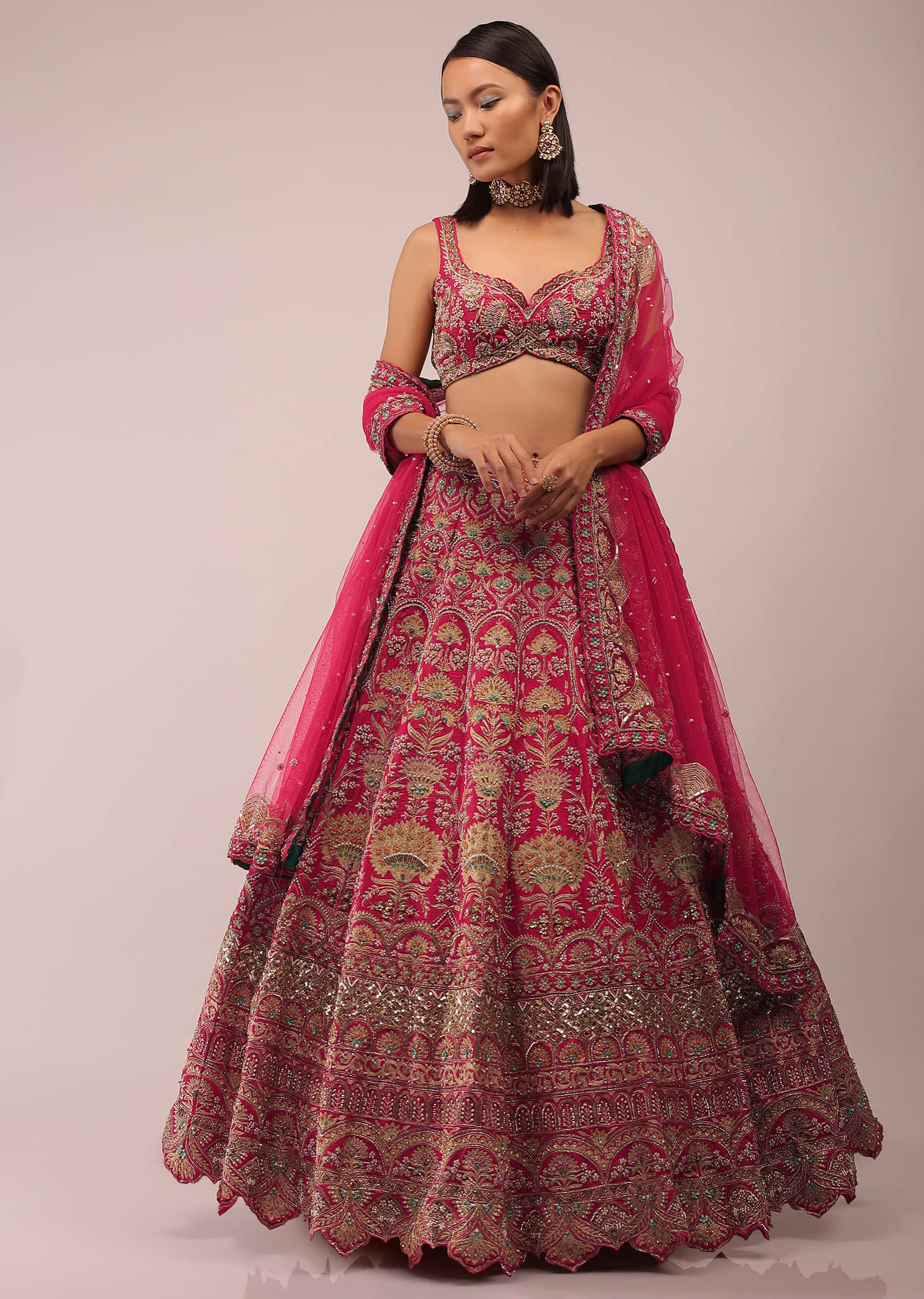 Rani Pink Lehenga In Golden Zari Work Embroidery Inspired By Mughal Architecture With Matching Net Dupatta In Embroidered Buttis
