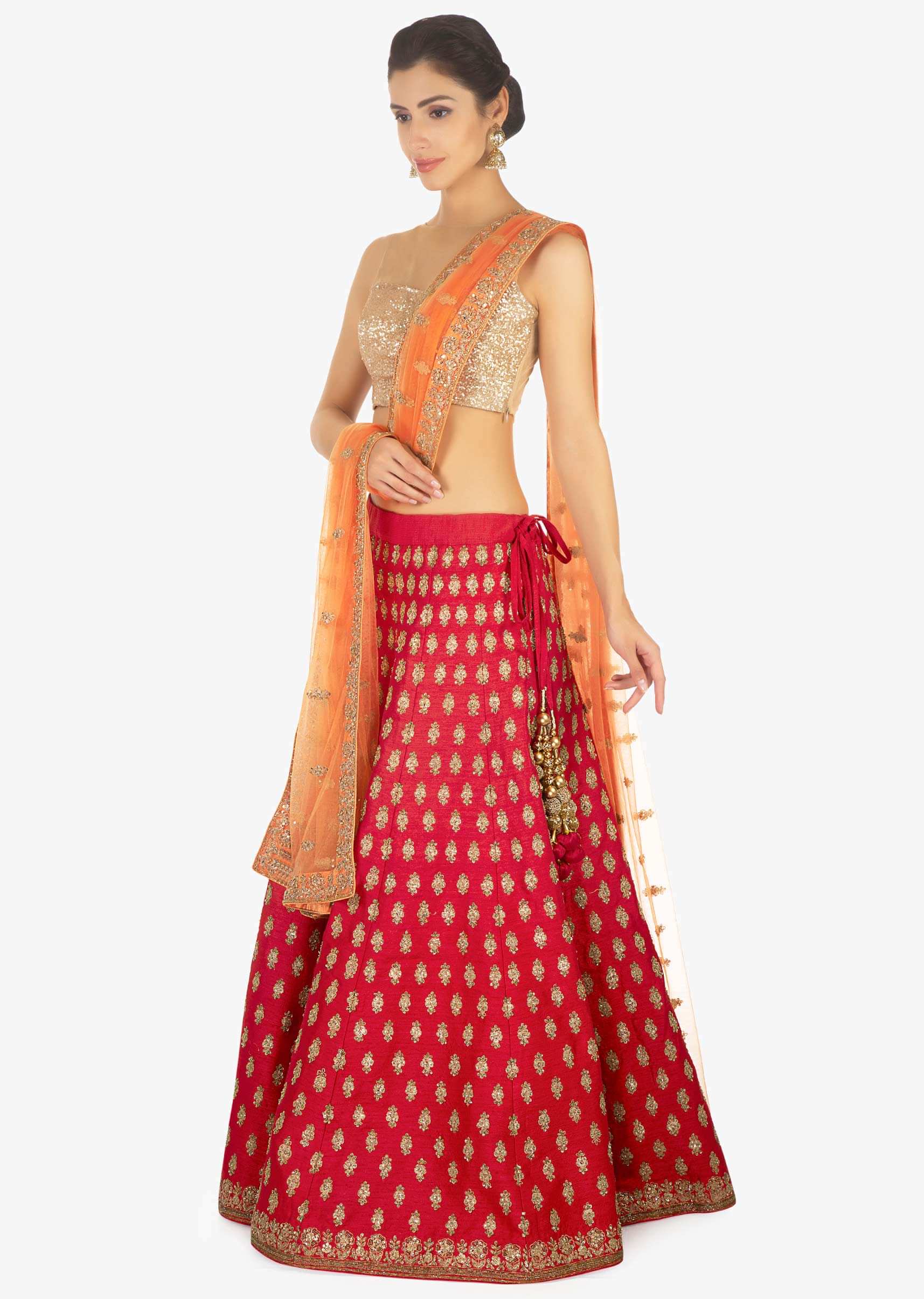 Red raw silk lehenga and blouse paired with a contrasting peach net dupatta