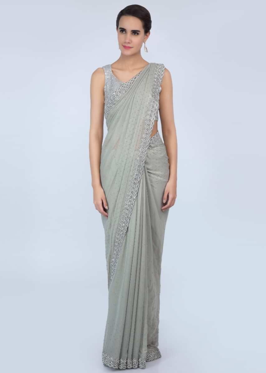 Sage green shimmer georgette saree adorn with moti scattered and heavy stone embroidered border only on Kalki