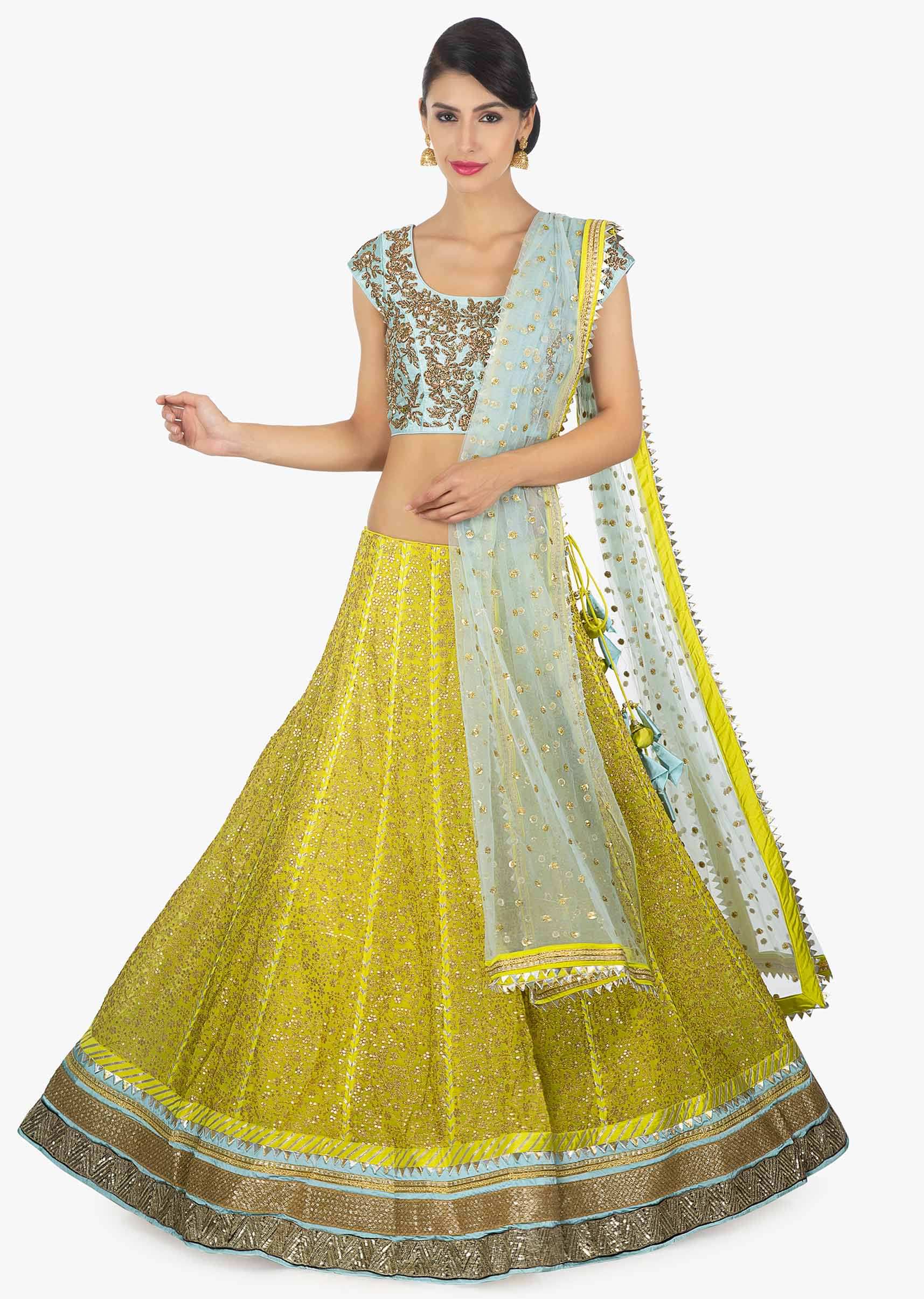 Sky blue raw silk embellished blouse paired with a canary yellow georgette lehenga and net dupatta