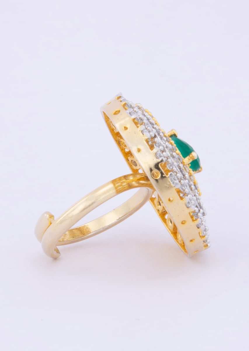Stone studded ring with cut work along with emerald green bead at the center only on kalki