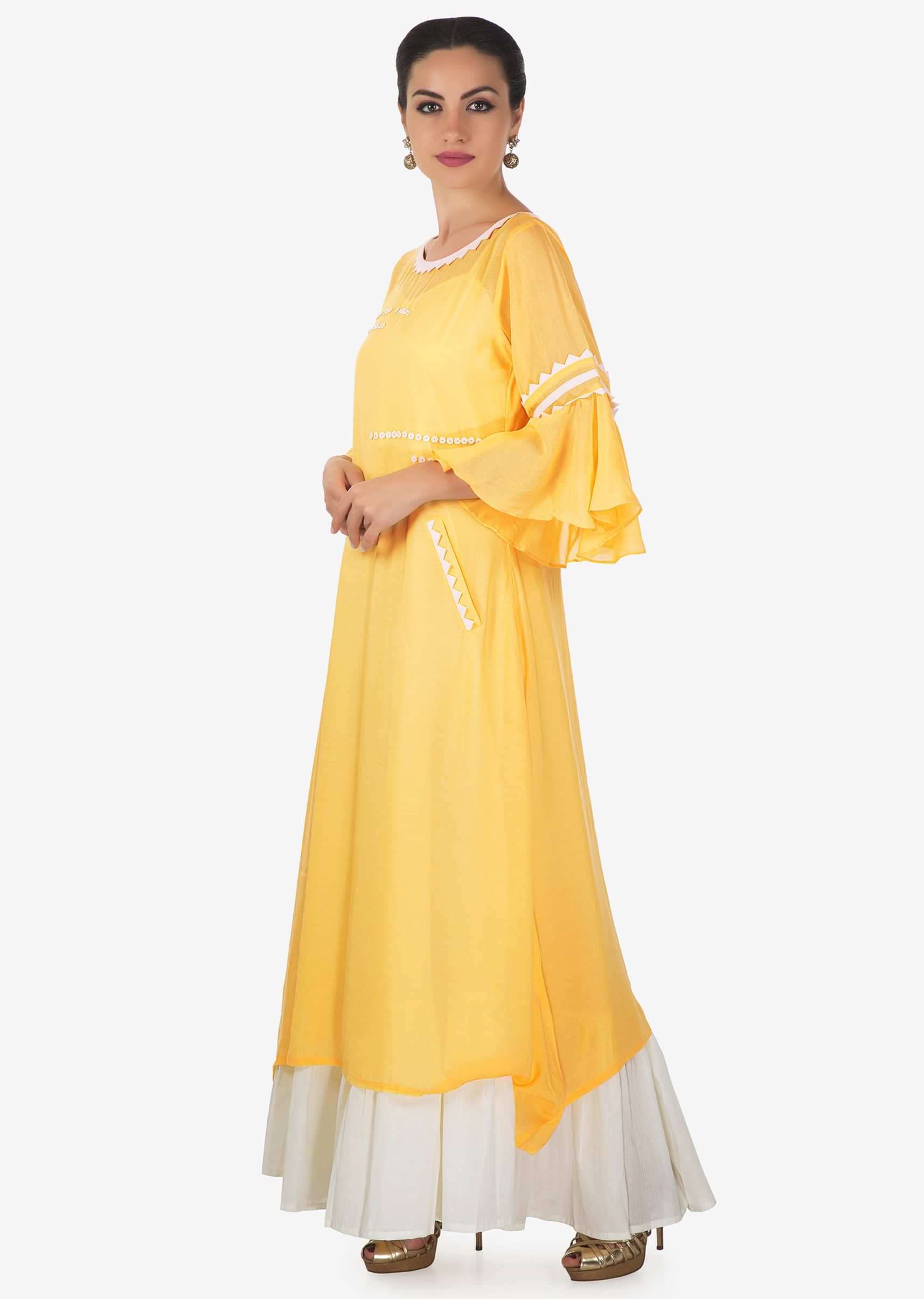 White long kurti matched with yellow top layer highlighted in fancy buttons only on Kalki
