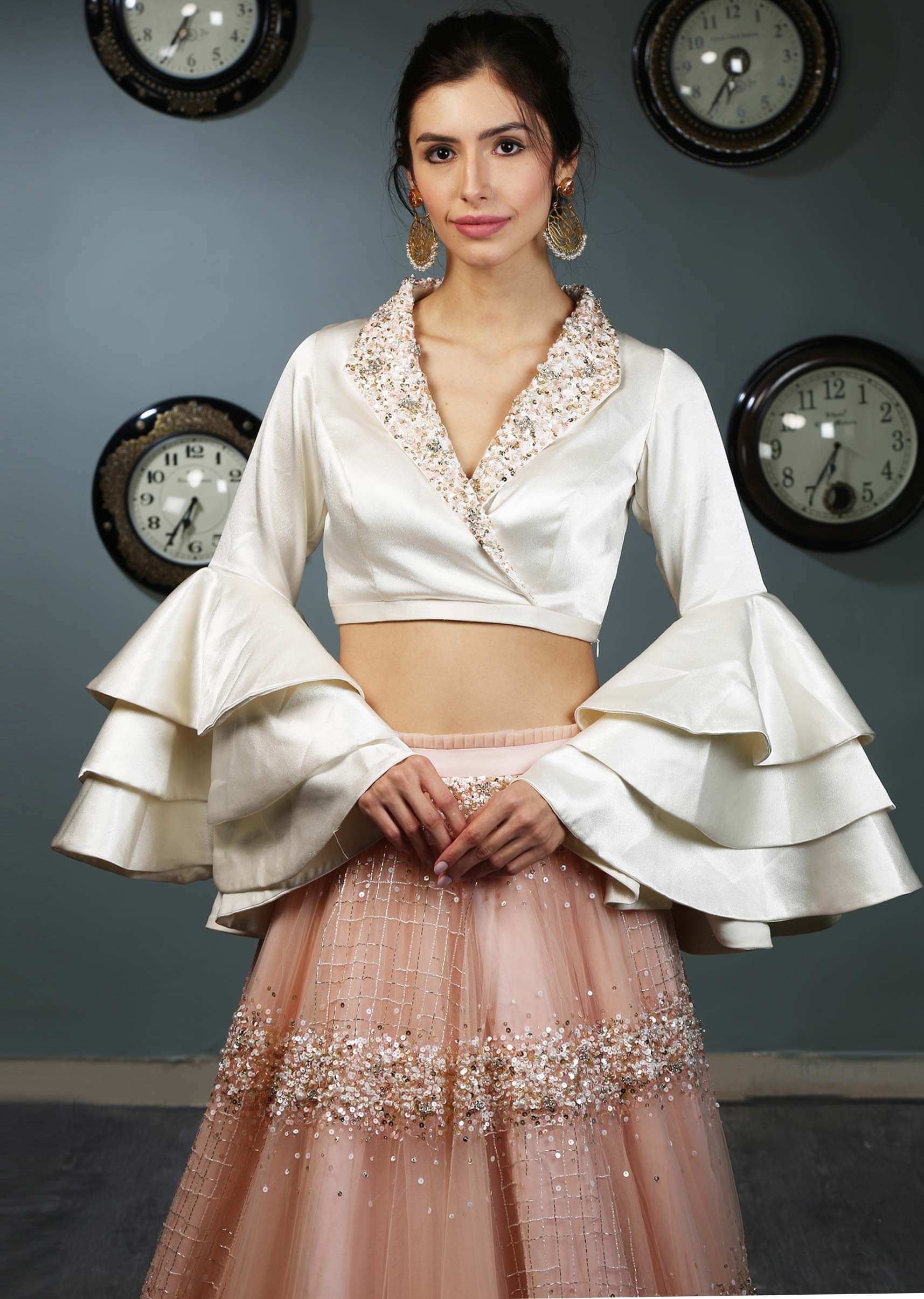 White satin blouse with layered frill sleeves paired with peach  net skirt in moti and sequins  embroidery