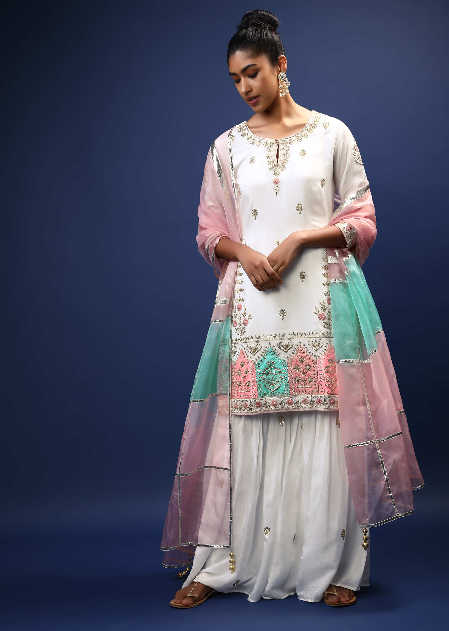 White Sharara Suit In Cotton With Gotta Patti Embroidered Buttis And A Multicolored Applique Work On The Border  