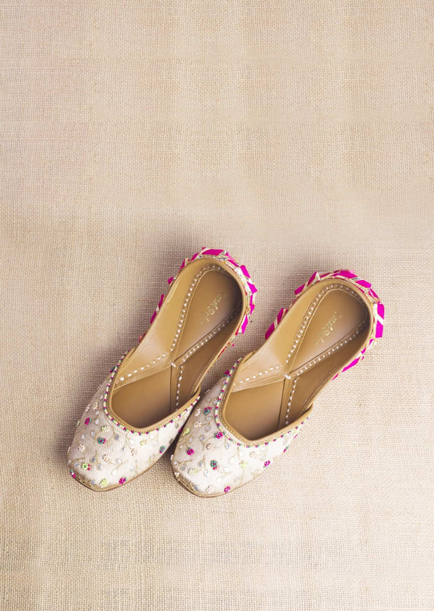 Champagne Gold Juttis In Heavy Linen With Vibrant Bead Work In Flower And Leaf Motifs By Vareli Bafna