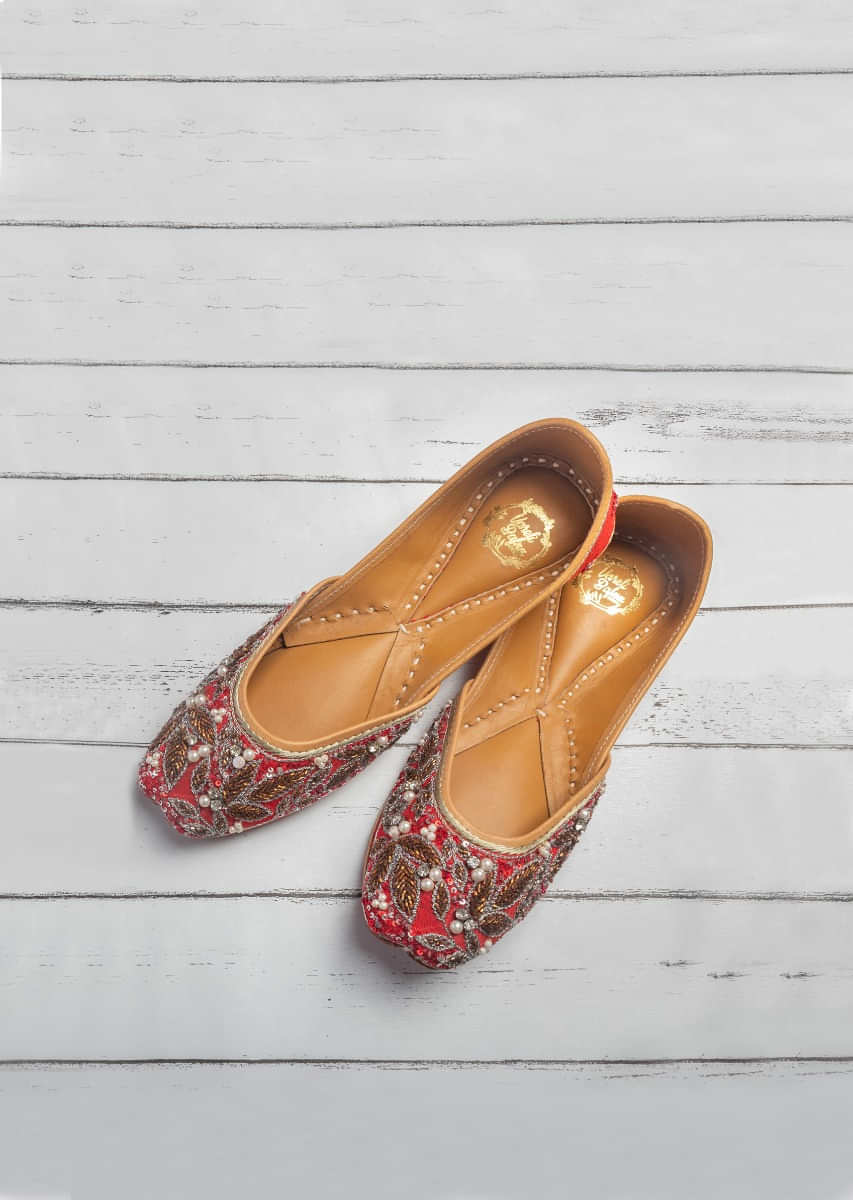 Red Juttis In Raw Silk Heavily Embroidered With Moti, Zardosi And Multi Colored Cut Dana In Floral Motifs By Vareli Bafna